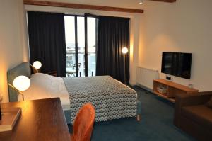 a hotel room with a bed and a television at Gudauri Atrium Redco in Gudauri