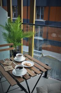 a wooden table with two cups of coffee on it at Gudauri Atrium Redco in Gudauri