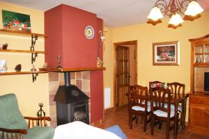 a living room with a fireplace and a table and chairs at Casa Rural El Arranca in Riópar