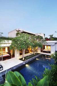 a villa with a swimming pool in front of a building at Kedonganan Beach Villas in Jimbaran