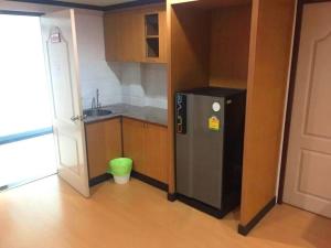 a small kitchen with a refrigerator and a sink at Cordial serviced apartment in Hua Hin