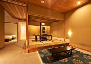 a living room with a table and a bed at Aoi Hotel Kyoto in Kyoto
