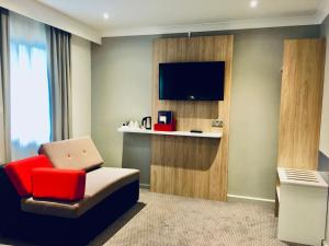 a living room with a couch and a tv at Holiday Inn Express London Victoria, an IHG Hotel in London