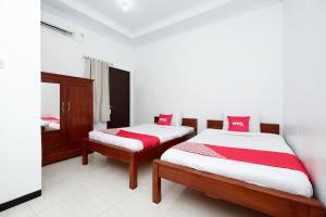 Tempat tidur dalam kamar di OYO 2058 Griya Ria