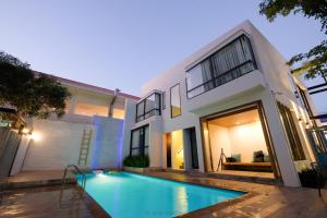 a house with a swimming pool in front of it at NornDee Hotel in Hua Hin