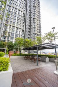 a picnic table with a canopy in front of a large building at Lovely 3-bedroom condo with pool for 8 pax - Cheras in Kuala Lumpur