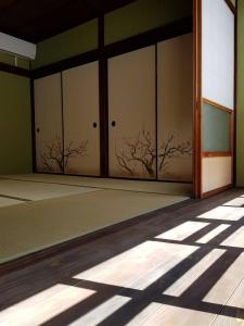 an empty room with doors with trees on the wall at むつわ柒 in Kanazawa