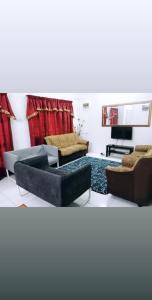 uma sala de estar com dois sofás e uma televisão em Homestay Mama Razzin em Kuala Kangsar