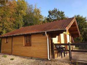 a large wooden cabin with a roof at Chalet des Grands Prés in Gercourt-et-Drillancourt