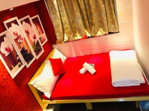 Habitación pequeña con cama roja y cruz. en Delta Lounge, en Hong Kong