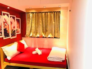 1 cama roja con almohadas blancas y ventana en Delta Lounge, en Hong Kong