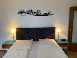 a bedroom with a large bed with two lamps on tables at Pension Appartementhaus Hus Möhlenbarg in Cuxhaven
