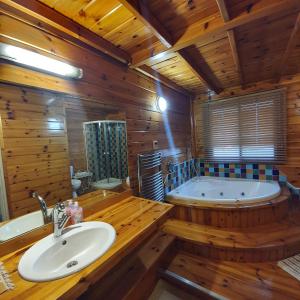 a bathroom with a large tub and a sink and a tub at בחצר של טובה in H̱azon +6 photos