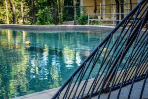 un bassin d'eau bleue avec une clôture métallique dans l'établissement Ambalama Leisure Lounge, à Hanwella