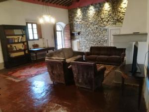 a living room with two couches and a stone wall at Villa Migliorati in Vaiano