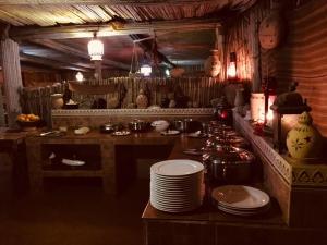a kitchen with a counter with plates on a table at Nomadic Desert Camp in Al Wāşil
