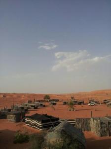 a view of a desert with a tent and a field at Nomadic Desert Camp in Al Wāşil