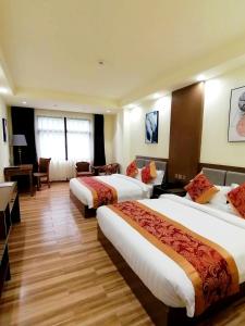 um quarto de hotel com duas camas e uma secretária em Hotel Tugos em Baguio