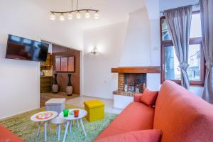 un salon avec un canapé rouge et une cheminée dans l'établissement Minotavros Cozy Apartment in Heraklion, à Héraklion