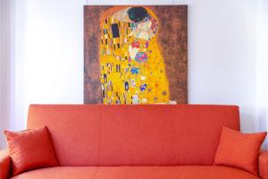 une peinture d'une femme est au-dessus d'un canapé rouge dans l'établissement Minotavros Cozy Apartment in Heraklion, à Héraklion