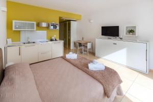 a living room with a kitchen with a large bed at Zeus Hotel - Aparthotel - Meeting & Congress in Catania