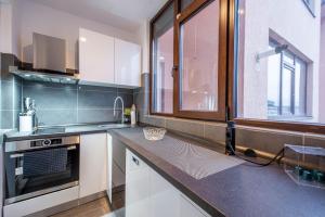 a kitchen with a counter with a sink and a window at Studio Residence Militari M2 in Bucharest