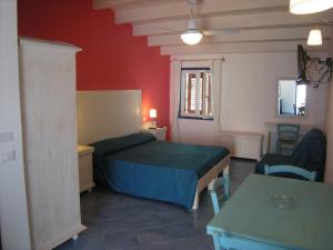 a bedroom with a bed and a table and chairs at Residence Timeo in Ustica