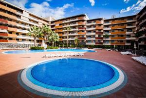 a large swimming pool in front of a building at Apartamentos Balcon de Los Gigantes in Puerto de Santiago