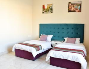 dwa łóżka siedzące obok siebie w pokoju w obiekcie Muscat Villa w Maskacie