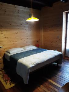 a bedroom with a bed in a wooden room at La vieille école in Montjovet