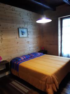 a bedroom with a bed in a wooden wall at La vieille école in Montjovet