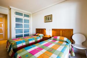 two twin beds in a room with a window at Apartamentos Balcon de Los Gigantes in Puerto de Santiago +34 photos