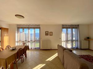 - une salle à manger avec une table, des chaises et des fenêtres dans l'établissement Villa Moroni, à Sondrio