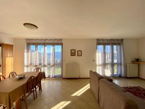 a dining room with a table and chairs and windows at Villa Moroni in Sondrio