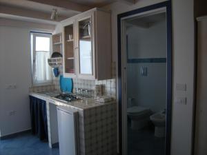 a small kitchen with a sink and a toilet at Residence Timeo in Ustica