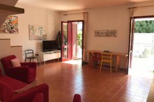 een woonkamer met een rode bank en een tafel bij Rosato apARTment in Porto Cesareo in Porto Cesareo