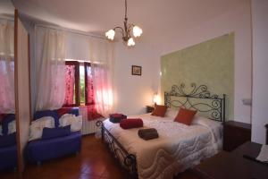 ein Schlafzimmer mit einem Bett und einem blauen Stuhl in der Unterkunft Agriturismo la Nicchia in Castelnuovo Berardenga