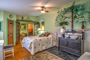 ein Schlafzimmer mit einem Bett und einem Baumbild an der Wand in der Unterkunft Russellville House with Garden - Walk to Main Street in Russellville