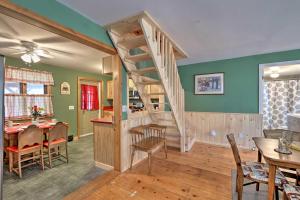 a living room with a staircase and a dining room at Cozy Bakers Mills Cottage Less Than 8 Mi to Gore Mountain! in Bakers Mills