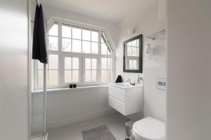 a white bathroom with a sink and a toilet at Kolorowe Pola Boutique B&B in Polanica-Zdrój +216 photos