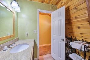 a bathroom with a sink and a mirror at Cabin with Deck and Hot Tub Walk to Big Bear Lake! in Fawnskin +22 photos