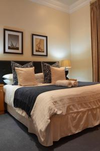 una camera da letto con un grande letto con cuscini di The Sandringham Bed and Breakfast a Durban