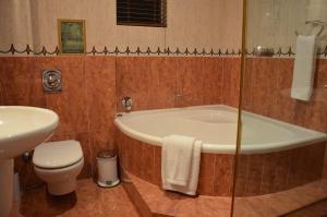 a bathroom with a tub and a toilet and a sink at The Sandringham Bed and Breakfast in Durban