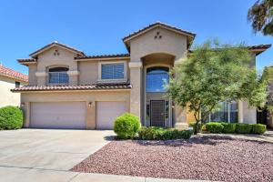 a house with a driveway and a tree at Spacious Litchfield Park Home with Yard, Heated Pool in Litchfield Park