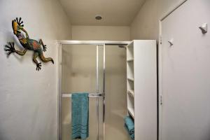 a bathroom with a shower with a dinosaur on the wall at Tucson Casita with Fireplace View Animals and Mtns in Tucson +16 photos
