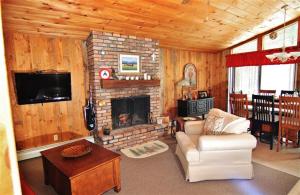 sala de estar con chimenea de ladrillo y TV en South Londonderry Home, Walk to Magic Mtn Ski Area, en Londonderry