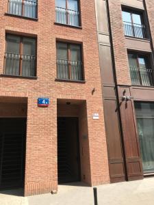 un edificio de ladrillo rojo con dos puertas de garaje en Central Port Warsaw Apartment, en Varsovia