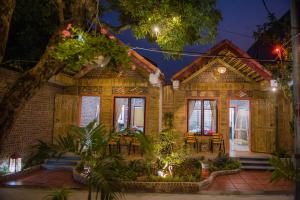 a house with chairs and tables in front of it at Tam Coc Three Princess Homestay in Ninh Binh