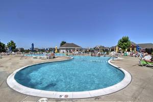 a swimming pool at a resort with people sitting around it at Ocean View Condo by Bethany Beach with Balcony! in Ocean View