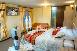 a bedroom with a bed with a bottle of wine at Los Portales de Chivay in Chivay